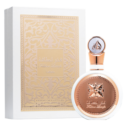 A bottle of Fakhar Rose perfume from Lattafa, with a rose gold cap and label featuring an intricate design. Clone / dupe of / inspired by Givenchy - L’Interdit perfume. Lattafa Fakhar Eau de Parfum in luxurious white and gold packaging, showcasing intricate embossed Arabic design and round bottle with rose-gold detailing.