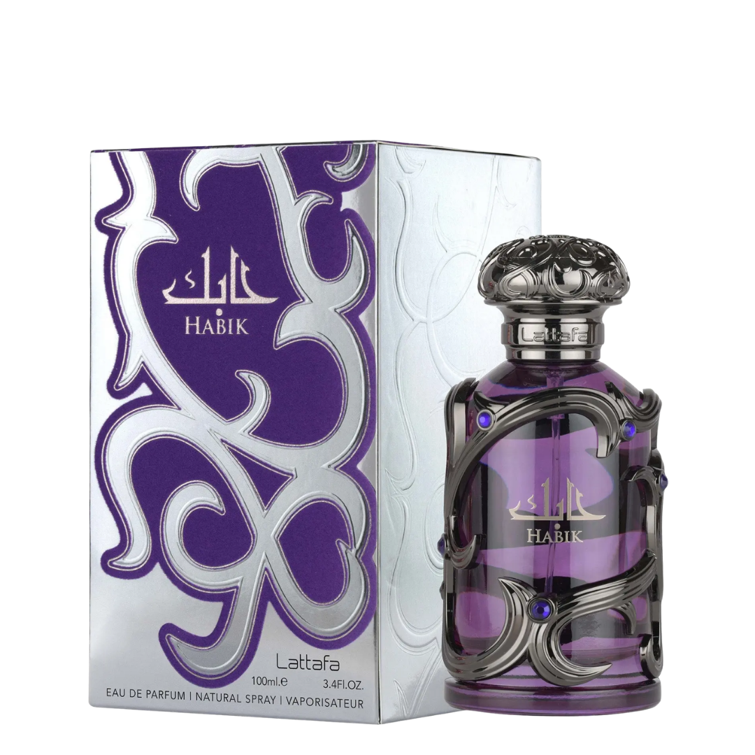 A bottle of Habik Lattafa Eau de Parfum next to its retail box. The bottle is purple glass with an ornate silver metal cage and a silver cap, while the box is white and purple with silver patterns.