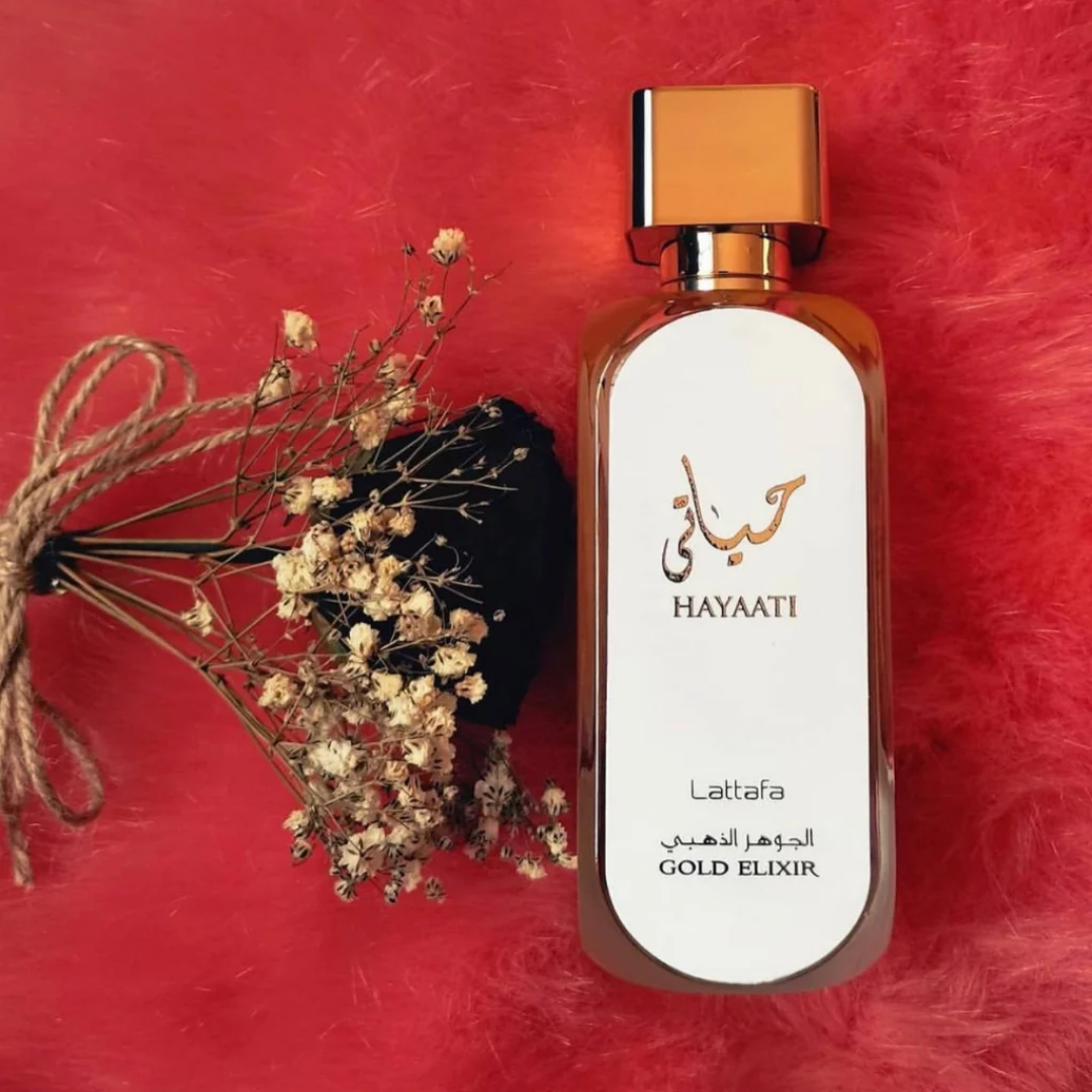 Perfume bottle with dried flowers on a red background. Lattafa Hayaati Gold Elixir Unisex Perfume