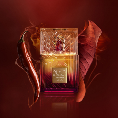 Lattafa Khamrah Dukhan Eau de Parfum surrounded by red chili pepper and autumn leaves – bold smoky-spicy unisex fragrance with warm oriental undertones.