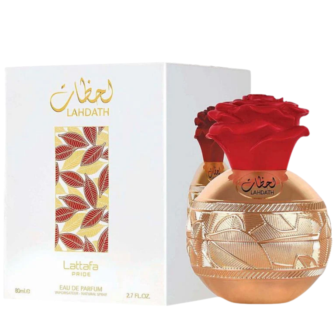 Lahdath Lattafa Pride Eau de Parfum bottle with a red rose cap next to its white packaging box featuring gold and red leaf patterns.