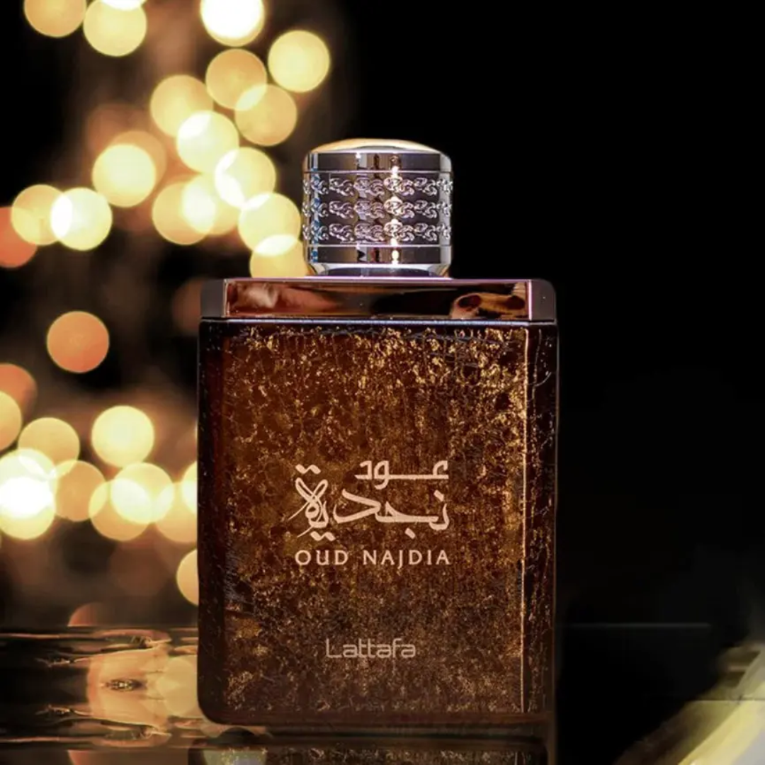 Lattafa Oud Najdia perfume bottle with blurred lights in the background