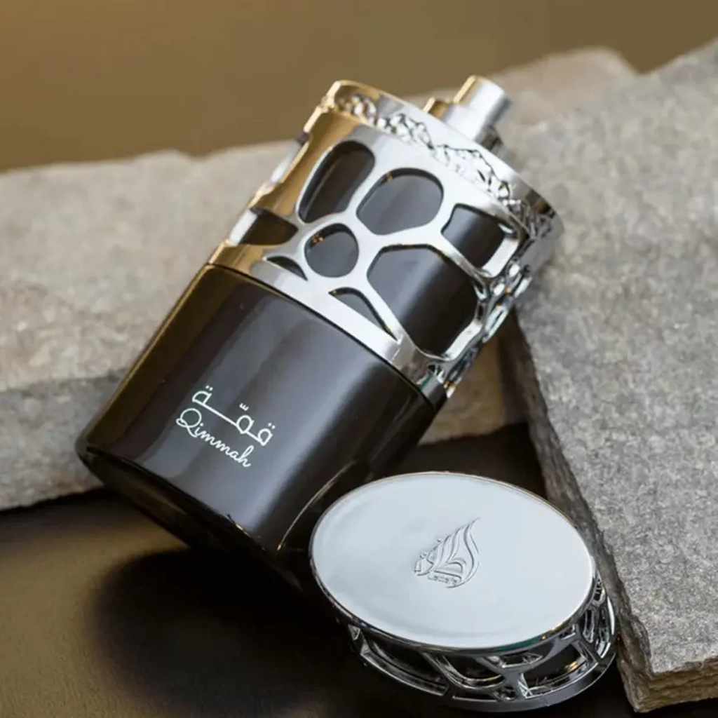 Perfume bottle with decorative cap on stone surface. Lattafa Qimmah for Men Perfume