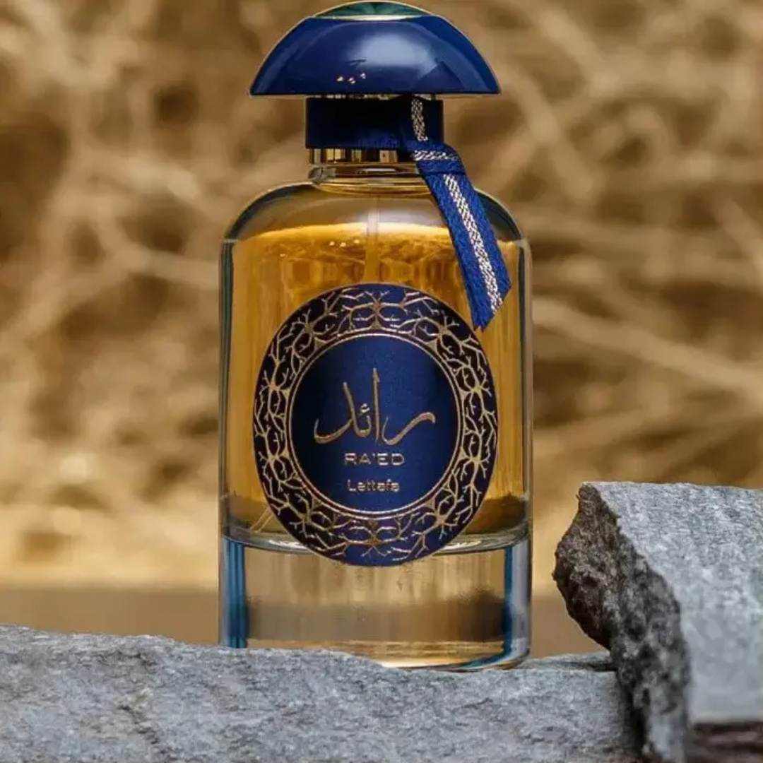 Perfume bottle with blue cap and label on a stone surface with a natural background. Lattafa Ra'ed Luxe Unisex Perfume