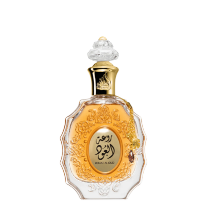 A bottle of Rouat Al Oud perfume by Lattafa, featuring a clear glass container with gold and ornate detailing, a crystal stopper, and a label with the product name.
