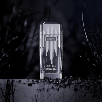 Luxury perfume bottle labeled 'Luxuria Intense' on a dark background with foliage.