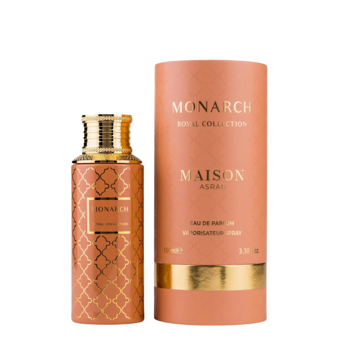 Maison Asrar Monarch Royal Collection Eau de Parfum bottle next to its cylindrical cardboard packaging box, both in a warm peach color with gold lettering and patterns, on a solid white background.