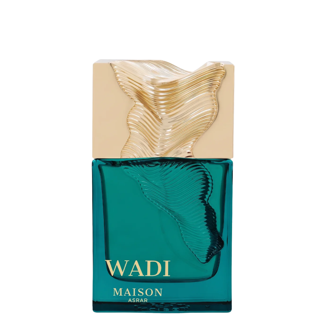 Maison Asrar Wadi perfume bottle with a translucent teal green glass body, a textured gold cap, and gold lettering on a white background.