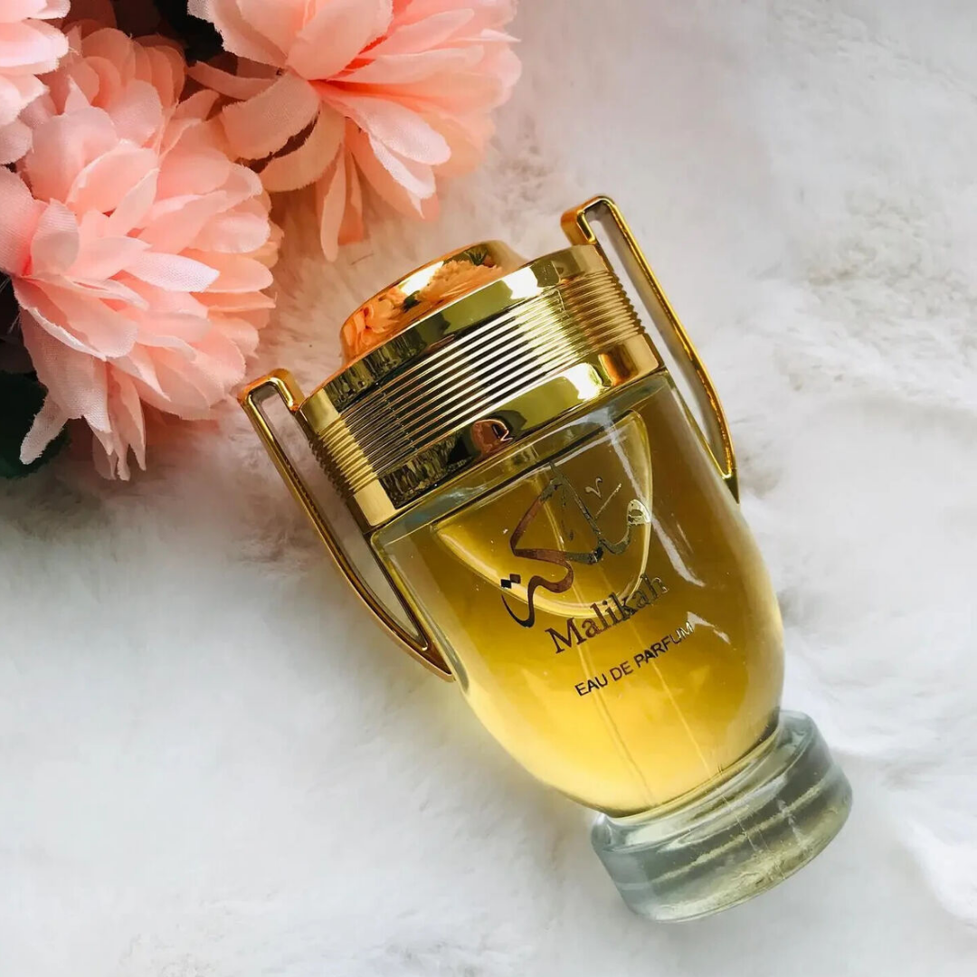 Gold Malika perfume bottle with pink flowers on a white background. Malikah Womens Perfume by Ard Al Zaafaran
