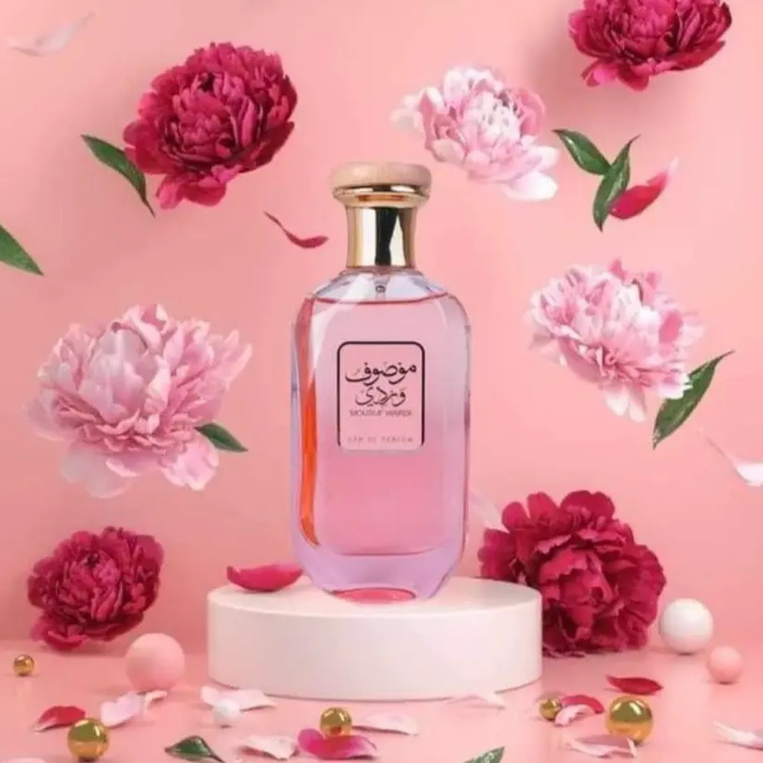 Beautiful Mousuf Wardi Eau de Parfum surrounded by pink peonies and petals, romantic floral fragrance by Ard Al Zaafaran, perfect scent for special occasions. 