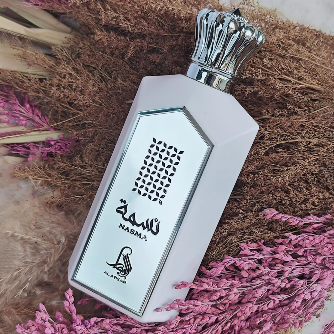 Perfume bottle with 'Nasma' branding on a textured surface with pink flowers