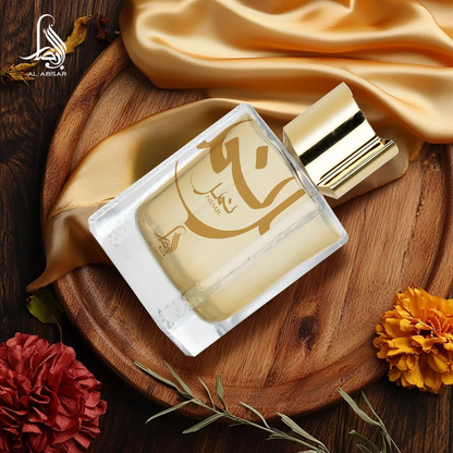 Perfume bottle with gold accents on a wooden tray with fabric and flowers
