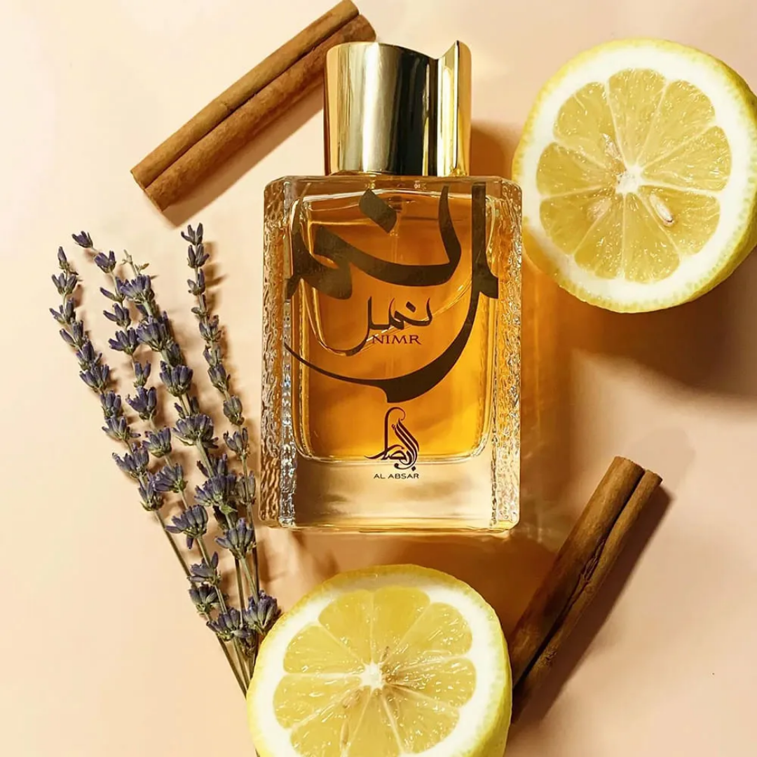 Perfume bottle with lemon slices, lavender, and cinnamon sticks on a beige background