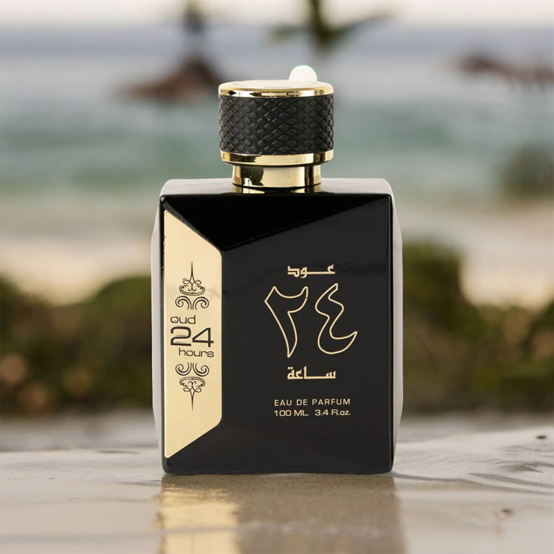 Black and gold perfume bottle with Arabic text on a blurred natural background