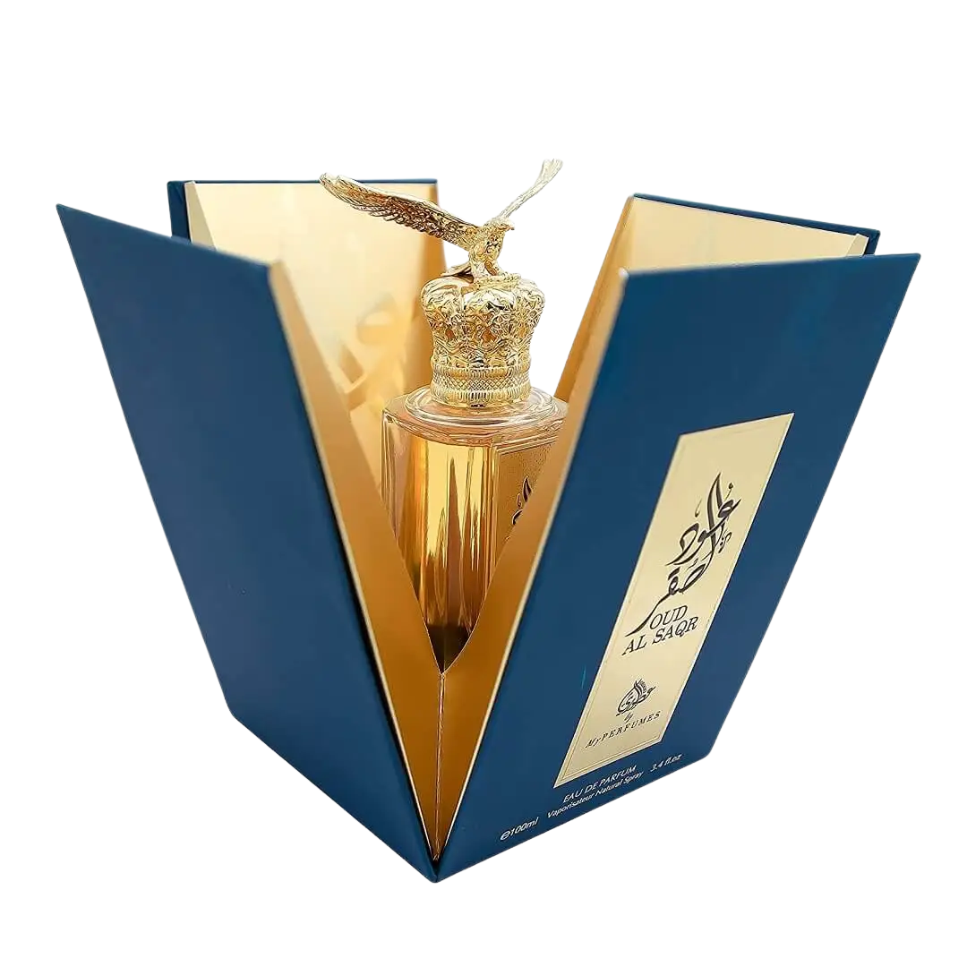Gold perfume bottle in a blue triangular box on a white background. Oud Al Saqr by Arabiyat Prestige Unisex Perfume
