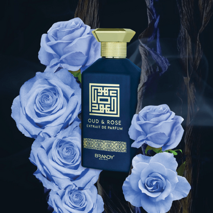 Perfume bottle labeled 'Oud & Rose' surrounded by blue roses on a dark background. Oud & Rose by Brandy Designs Unisex Perfume