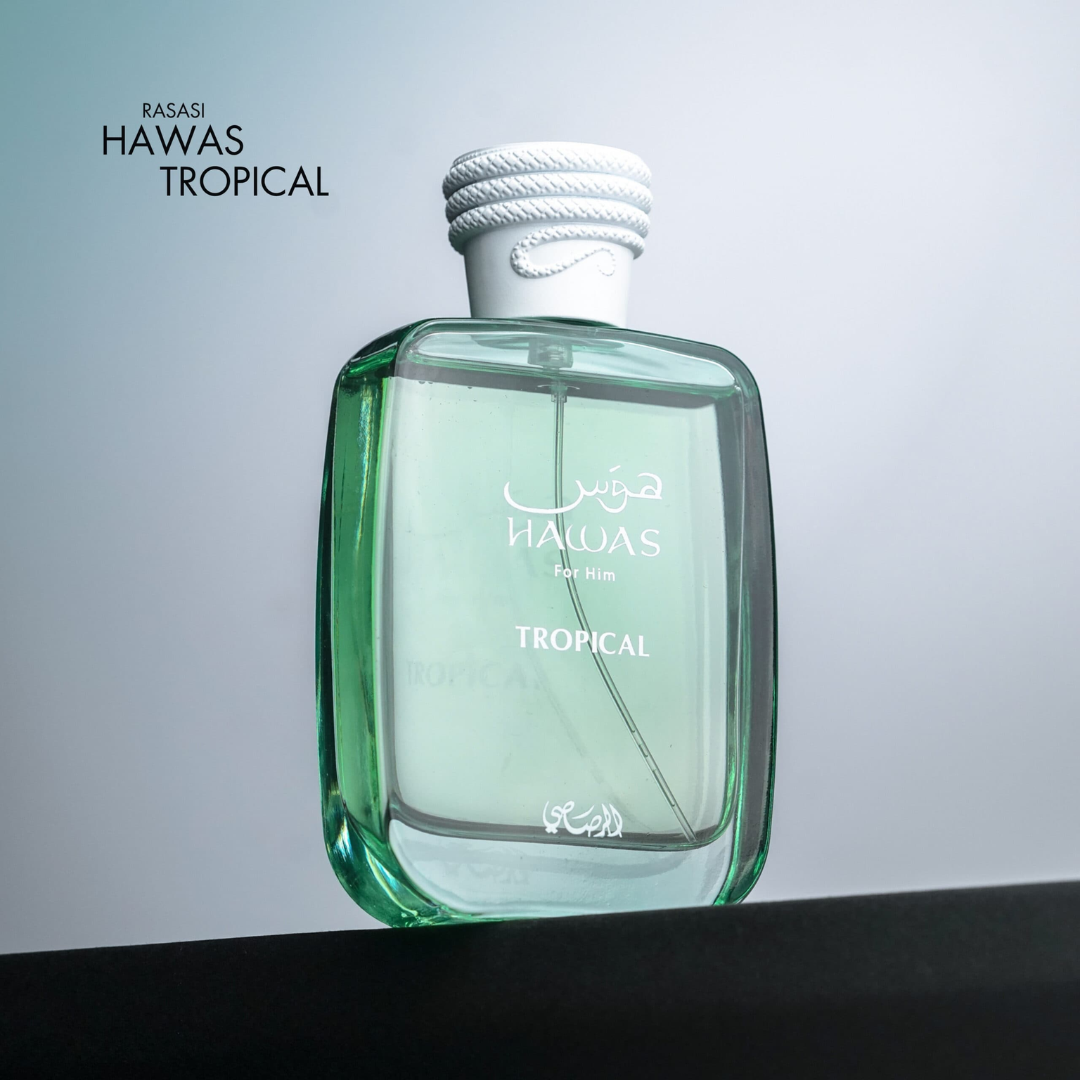 Green perfume bottle labeled 'Hawas Tropical' by Rasasi on a gradient background