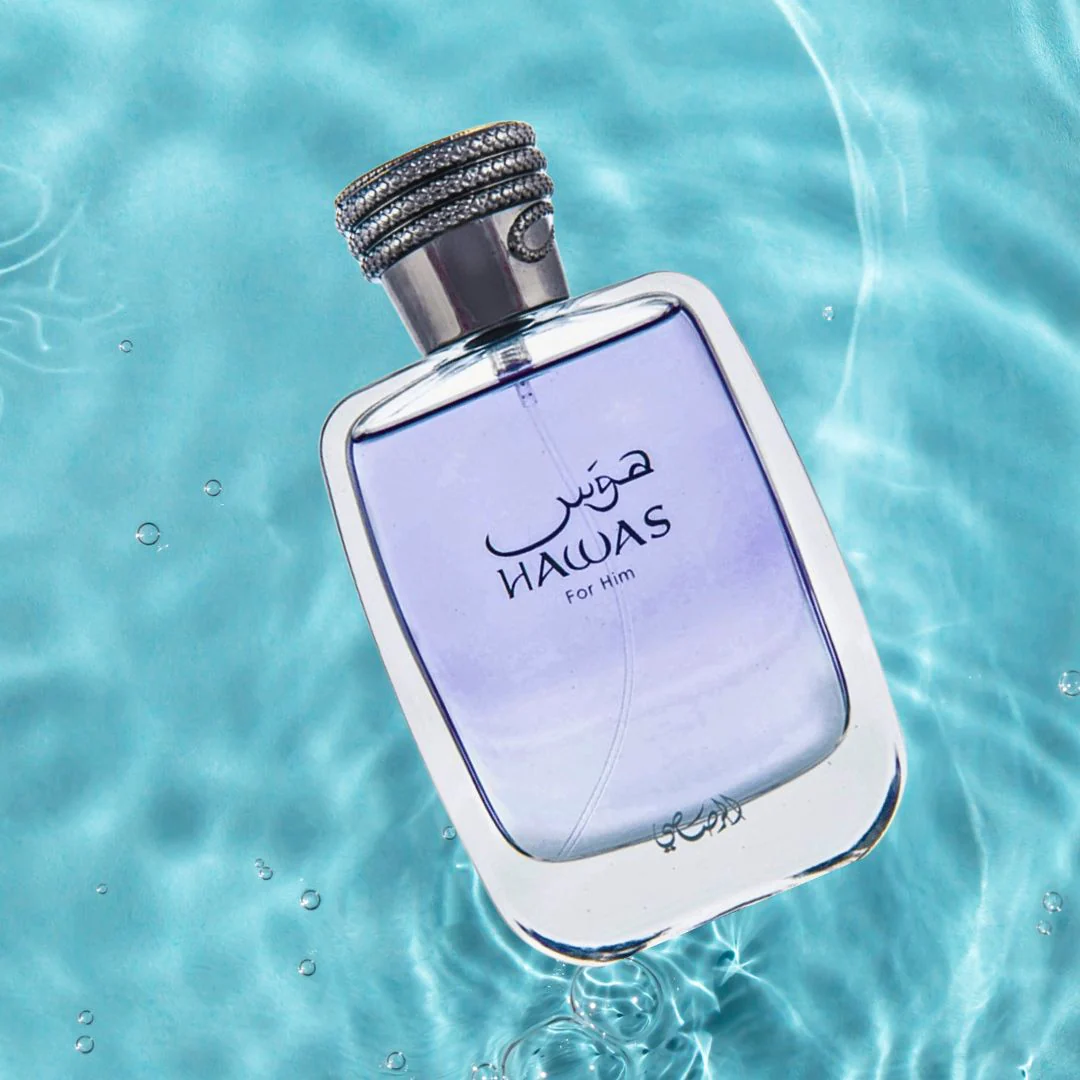Perfume bottle labeled 'Hawas' floating on water with a blue gradient background