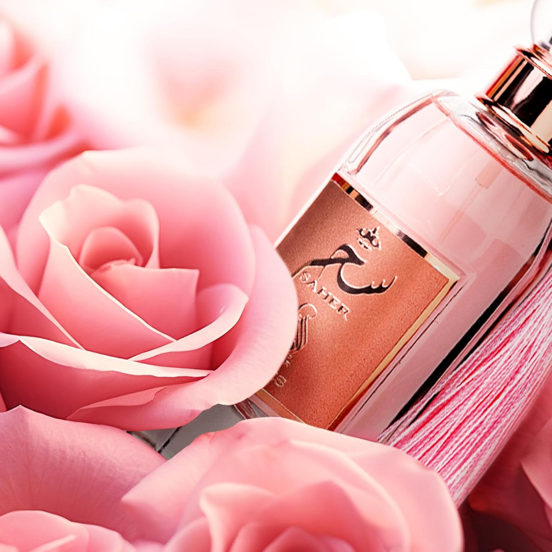 Perfume bottle with pink roses in the foreground. Saher Roses by Al Absar Womens Perfume