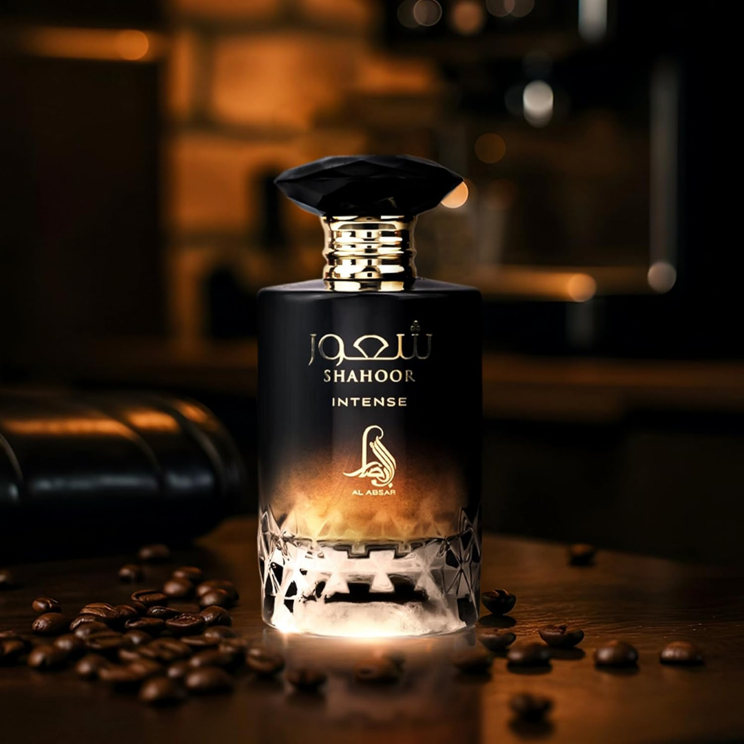 Perfume bottle labeled 'Shahoor Intense' with coffee beans on a wooden surface.