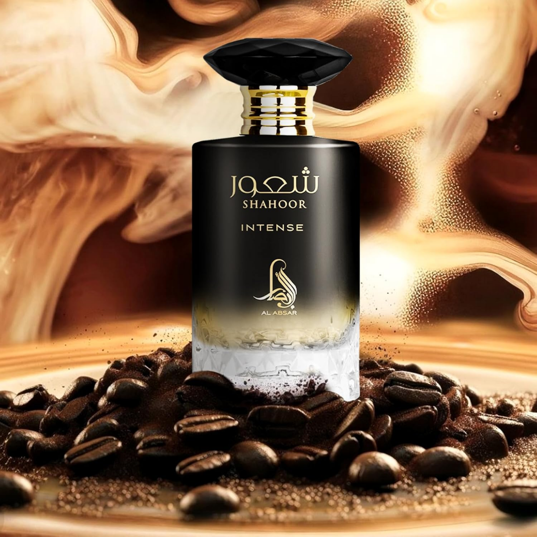 Perfume bottle labeled 'Shahoor Intense' surrounded by coffee beans and coffee grounds.
