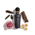 Surrati Gray Oud perfume bottle with decorative wood, rose and amber-coloured props.