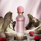 Surrati Miss World perfume bottle on stone with rose petals.