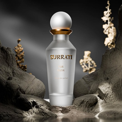 Surrati perfume bottle on a rocky surface with a dark background