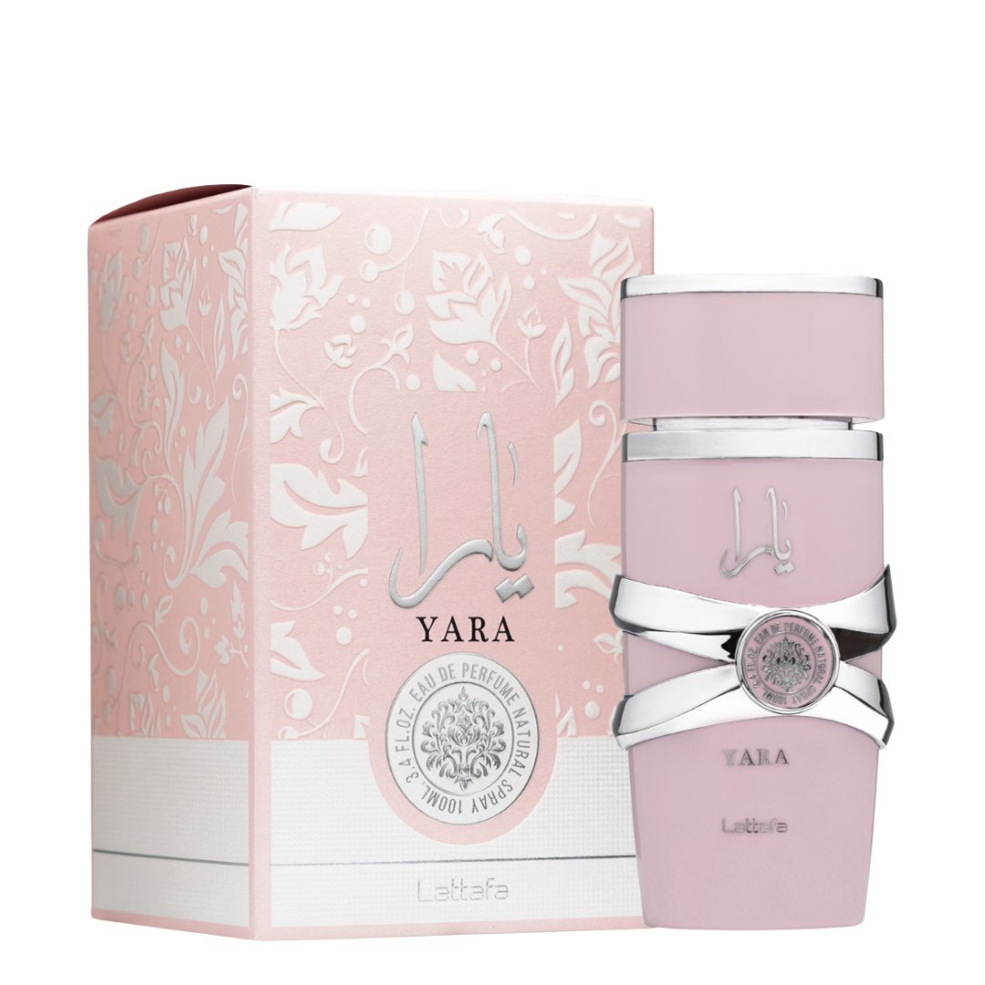 A bottle of Yara Eau de Parfum by Lattafa, featuring a pink hue with a silver-colored cap and label design. . Lattafa Yara Eau de Parfum 100ml bottle and pink floral embossed box with silver Arabic calligraphy, feminine fragrance with sweet, vanilla, and tropical accords.