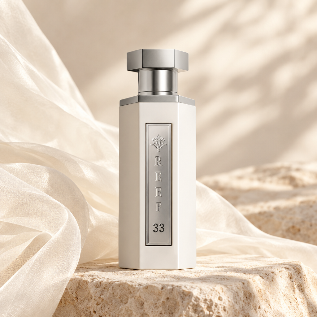 Reef 33 White perfume bottle on pale stone beside cream fabric.