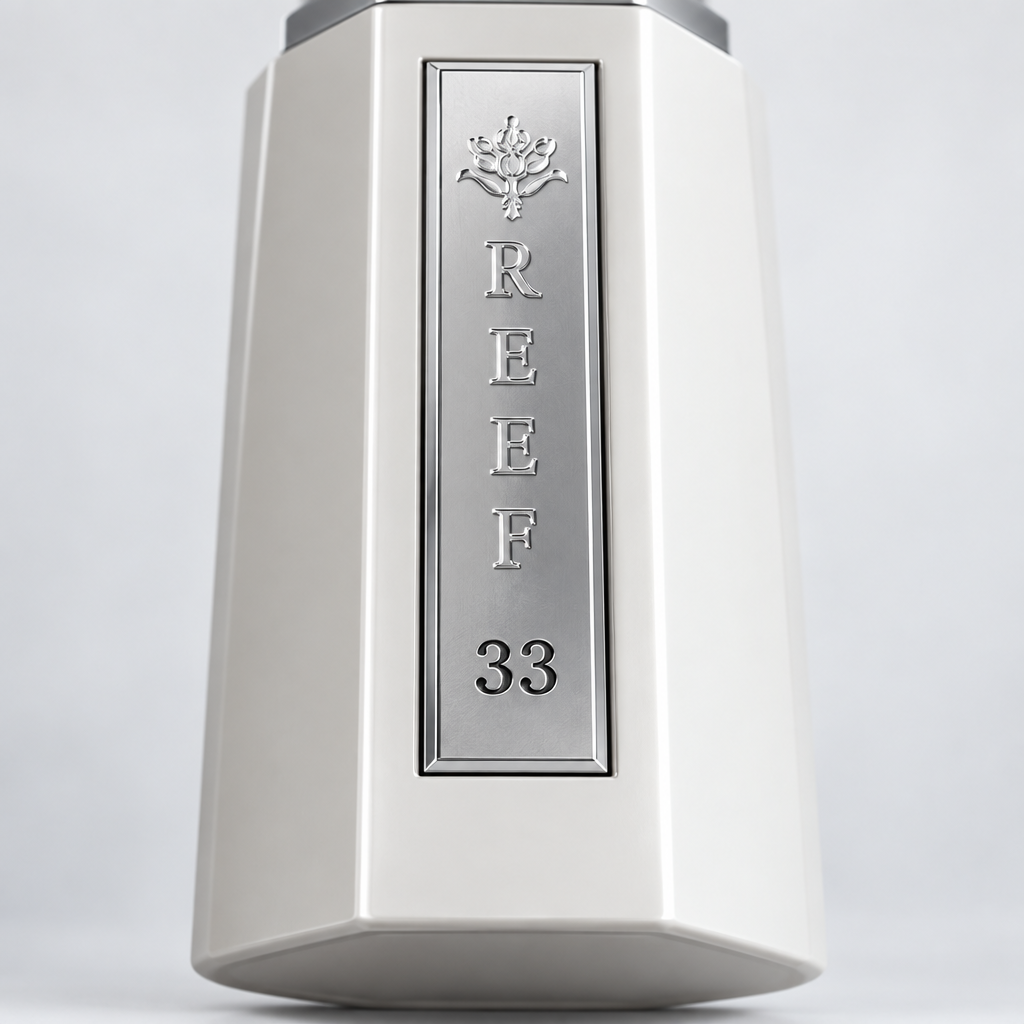 Reef 33 White close-up of the silver front plaque on the white perfume bottle.